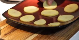 Приготовление картофельных чипсов. Нарежь картофель тонкими кружочками,  выложи на тарелку и поставь в микроволновку на 3 минуты. Затем переверни картофель на другую сторону и помести еще на 3 минуты. Посыпь чипсы солью или специями.